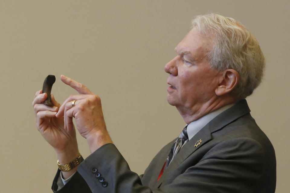 Butte County District Attorney Michael Ramsey gestures to the broken "C" hook, that investigators determined was the cause of the 2018 Camp Fire, during the criminal sentencing hearing in the trial of Pacific Gas & Electric Corp in Chico, Calif., Thursday, June 18, 2020. Pacific Gas & Electric on Thursday was fined $4 million for the deaths of 84 people killed in a nightmarish Northern California wildfire ignited by the its long-neglected electrical grid. The sentencing comes as the nation's largest utility prepares to end a 17-month bankruptcy proceeding triggered by the catastrophe. (AP Photo/Rich Pedroncelli, Pool)