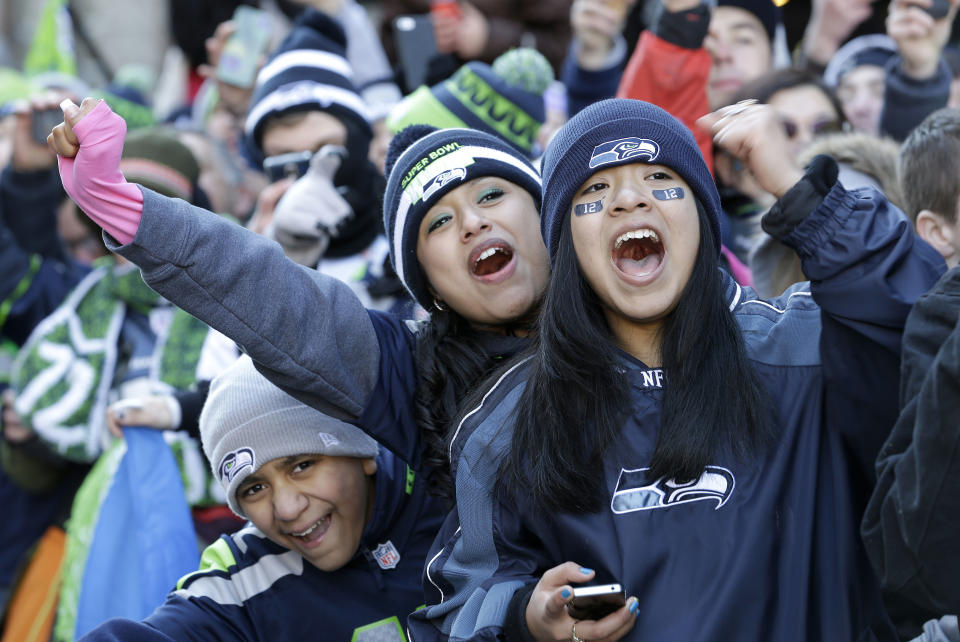 Seattle Seahawks fans cheer during the a parade for the NFL football Super Bowl champions, Wednesday, Feb. 5, 2014, in Seattle. The Seahawks defeated the Denver Broncos 43-8 on Sunday. (AP Photo/Elaine Thompson)