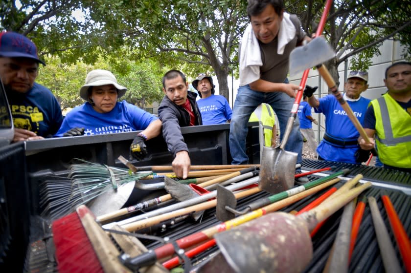 Day laborers from the Carecen Day Labor Center and the Idepsca Labor Center pick out shovels and other tools to add to the garden at Evelyn Thurman Gratts Elementary School in Los Angeles Friday morning. Day laborers prepare to help plant a student garden at Evelyn Thurman Gratts Elementary School in Los Angeles, CA Friday April 24, 2015. The workers were present to encourage continued funding by the City of Los Angeles for work center programs such as the Carecen Day Labor Center and the Idepsca Labor Center.