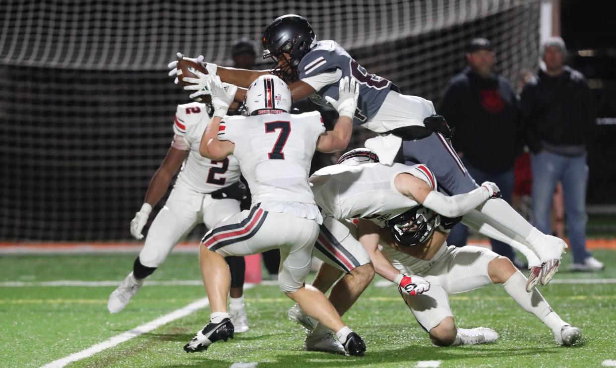 Benedictine's La'Don Bryant leaps over several North Oconee defenders for a touchdown during Friday night's quarterfinal game at Memorial Stadium.
