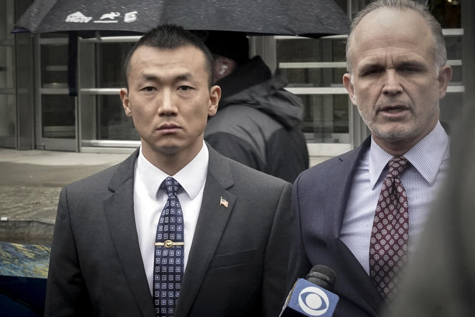NYPD officer Baimadajie Angwang, left, a naturalized U.S. citizen born in Tibet, and his attorney John Carman, right, hold a press briefing outside Brooklyn's Federal court after a judge dismissed spy charges against him, Thursday Jan. 19, 2023, in New York. Federal prosecutors dropped charges against Angwang, who authorities had initially accused of spying on independence-minded Tibetans on behalf of the Chinese consulate in New York. (AP Photo/Bebeto Matthews)