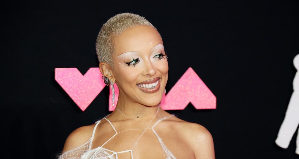 Doja Cat wore a unique outfit at the VMAs with spider web-like strands covering the top, she shaved her head, and wore bold and creative makeup.