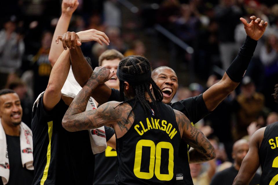 Utah Jazz guard Jordan Clarkson (00) celebrates with teammate Utah Jazz guard Kris Dunn (11) after Clarkson’s triple-double .