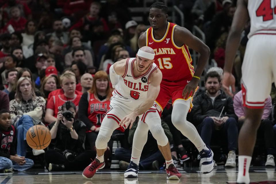 Chicago Bulls guard Alex Caruso loses the ball as he's guarded by Atlanta Hawks center Clint Capela (15) during the first half of an NBA basketball game Tuesday, Dec. 26, 2023, in Chicago. (AP Photo/Erin Hooley)