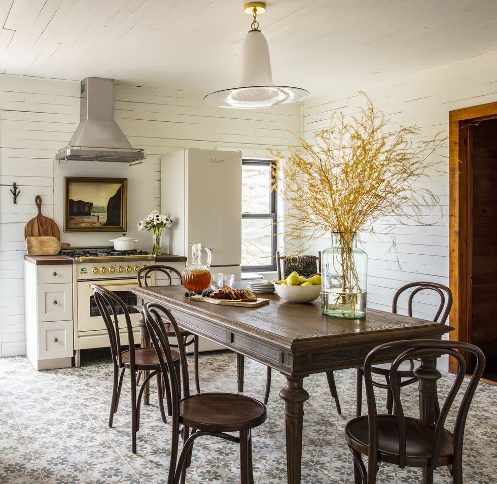 a kitchen with a dining room table with chairs and a stove