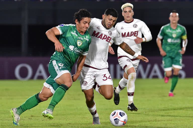 Colombia's Equidad Daniel Mantilla (L) and Argentina's Lanus Facundo Perez vie for the ball during the Copa Sudamericana football tournament group stage match, at the Defensores del Chaco stadium in Asuncion, on May 6, 2021. (Photo by NORBERTO DUARTE / AFP)