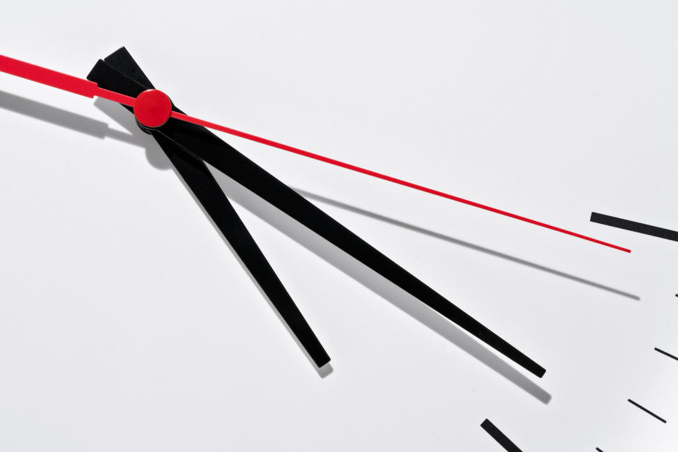 Extreme Close-up View of White Clock Face along with Black Hour Hand, Black Minute Hand and Red Second Hand.