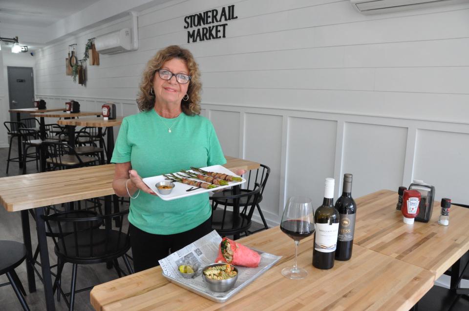 Susan Obey, a waitress at the new Stonerail Market restaurant in downtown Dover, shows some of the featured dishes available during the Capital Crawl Saturday, March 16 including asparagus wrapped in bacon and a blackened chicken mushroom wrap.