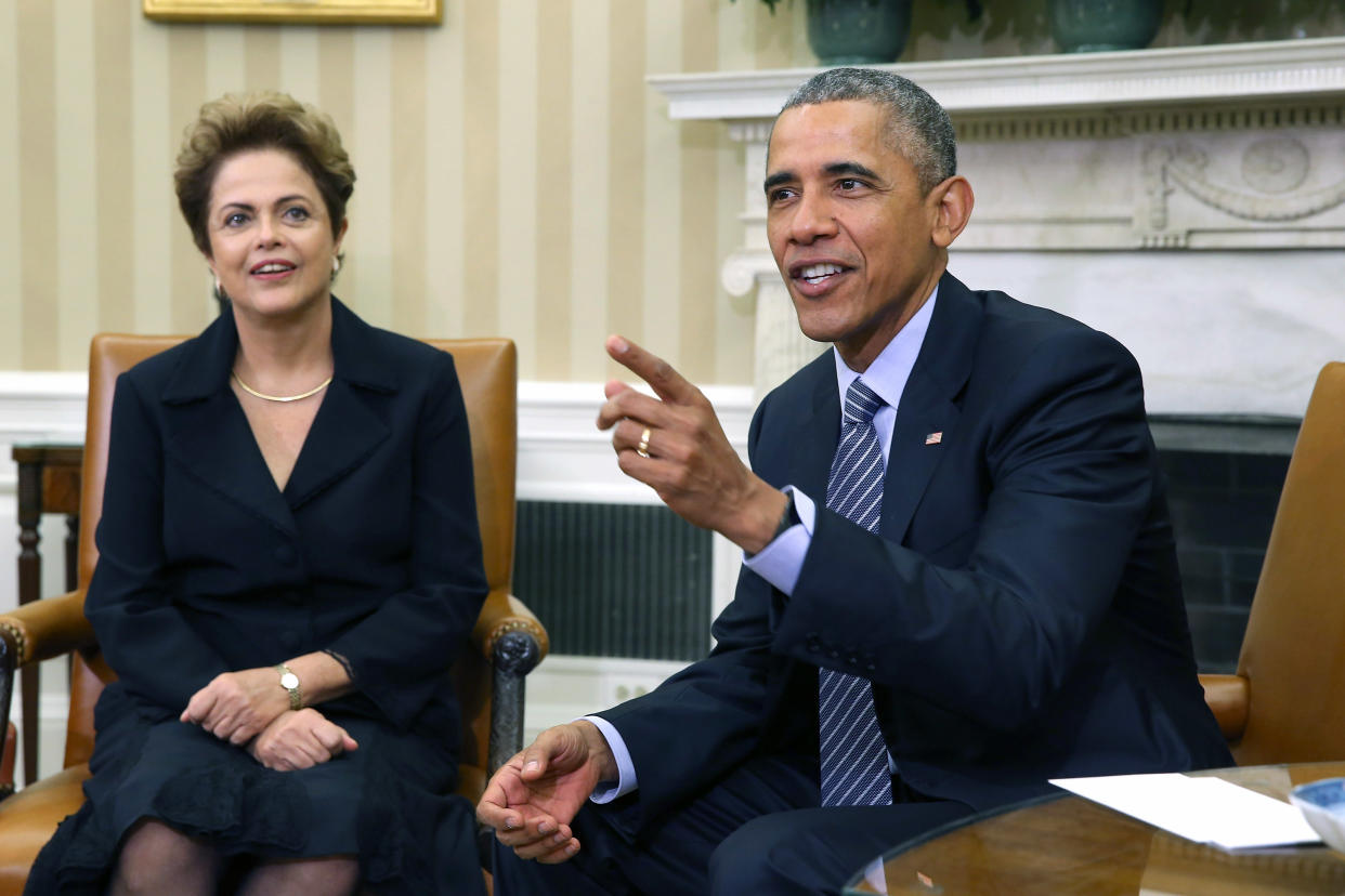 Brazilian President Dilma Rousseff looks attentive and amused, as President Barack Obama gestures with his index finger.