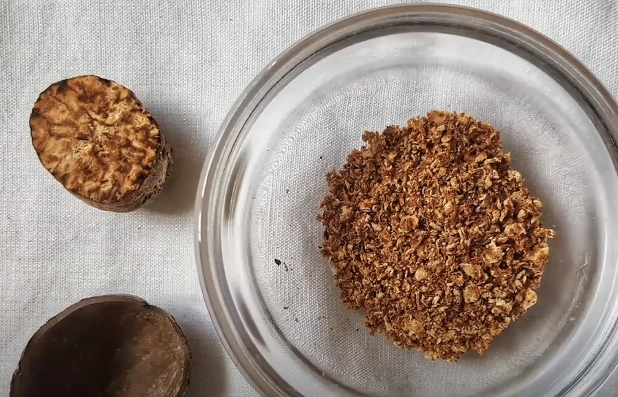 grated nutmeg and nutmeg seed in a small glass bowl