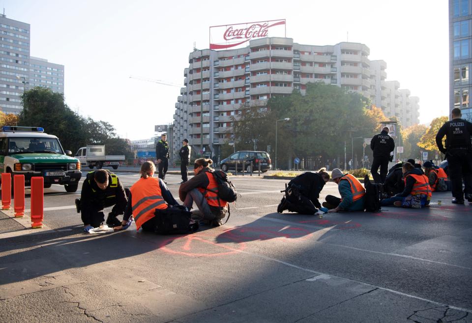 Demonstrierende der Bewegung "Letzte Generation" blockieren eine Kreuzung in Berlin.  - Copyright: picture alliance/dpa | Paul Zinken