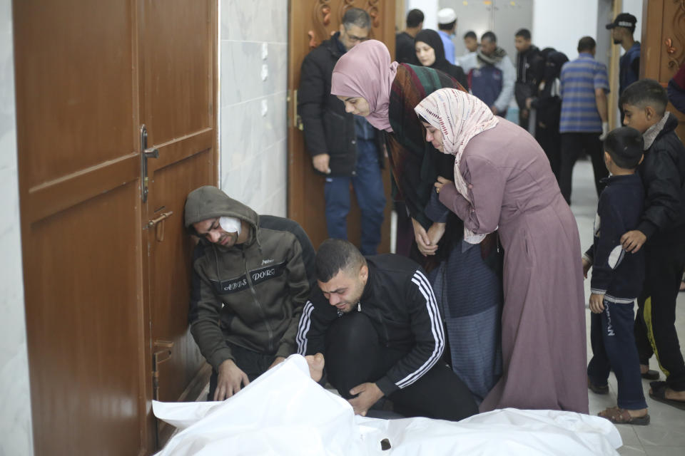 Palestinians mourn relatives killed in the Israeli bombardment of the Gaza Strip in Khan Younis, Tuesday, Dec. 26, 2023. (AP Photo/Hatem Ali)