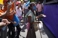 A woman begs for alms during a demonstration to show support for opposition leader Freddy Superlano, in Barinas, Venezuela, Saturday, Dec. 4, 2021. Superlano, who was leading the race for governor in Barinas State in the recent Nov. 21 regional elections, called for a protest this Saturday after a court ruling ordered new elections in the state and disqualified him from running. (AP Photo/Ariana Cubillos)