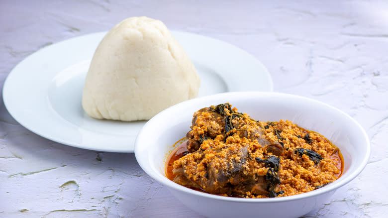 Pounded yam next to egusi soup with goat meat