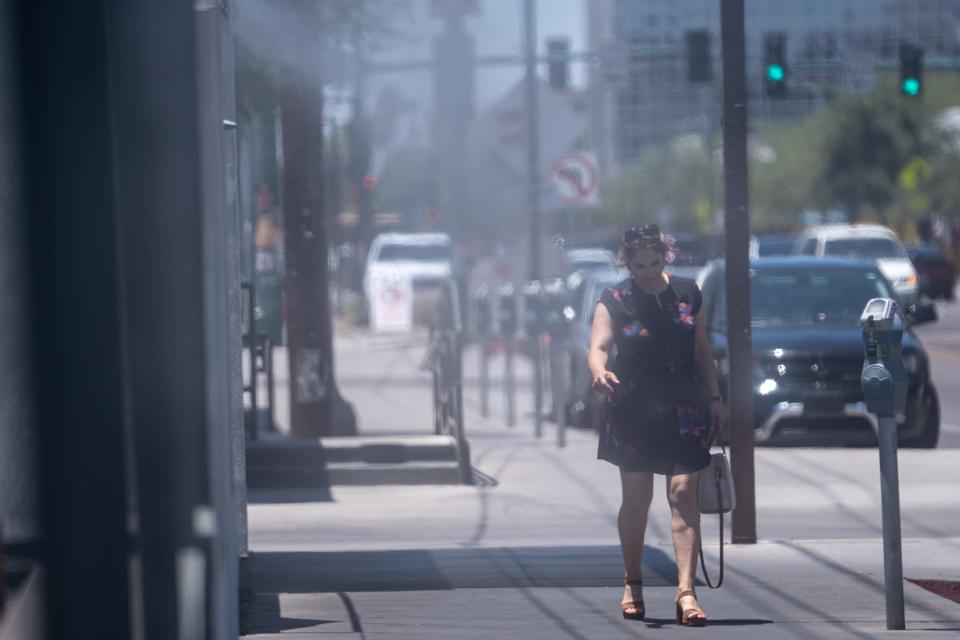 A person walks along Roosevelt Row in Phoenix on July 5, 2023. An Excessive Heat Warning issued by the National Weather Service is in effect until July 7 at 8 p.m.