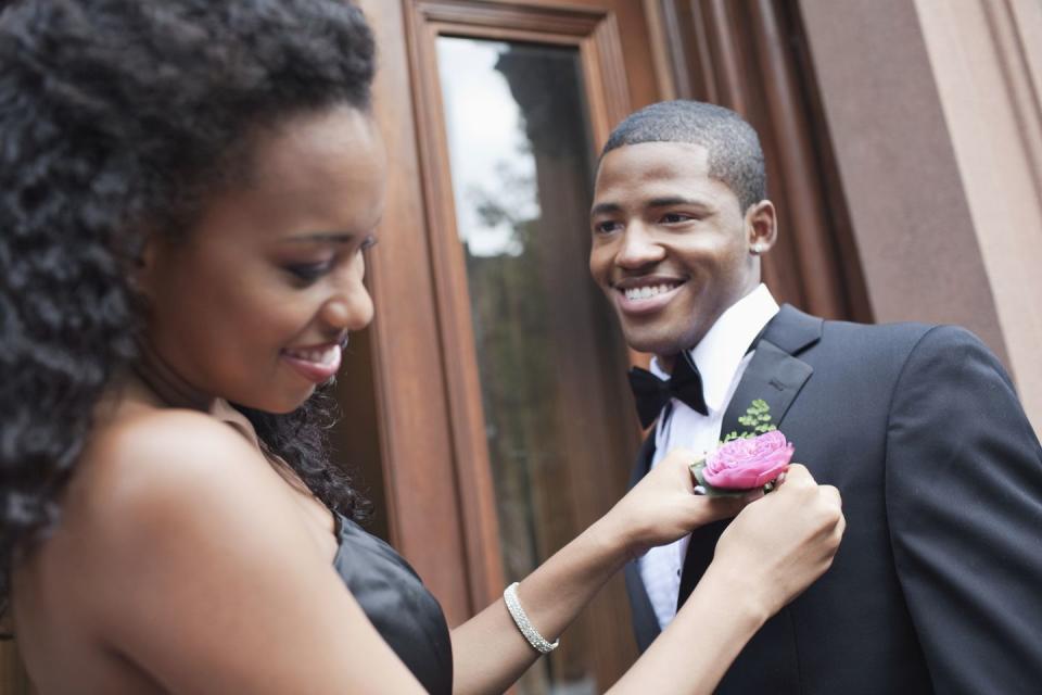 woman adjusting man's boutonniere