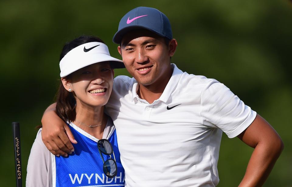 GREENSBORO, NC - AUGUST 19:  C.T. Pan of Taiwan stands on the 18th green with his wife and caddie Michelle Lin during the final round of the Wyndham Championship at Sedgefield Country Club on August 19, 2018 in Greensboro, North Carolina.  (Photo by Jared C. Tilton/Getty Images)