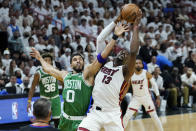 Miami Heat center Bam Adebayo (13) and Boston Celtics forward Jayson Tatum (0) go after a rebound during the first half of Game 7 of the NBA basketball Eastern Conference finals playoff series, Sunday, May 29, 2022, in Miami. (AP Photo/Lynne Sladky)