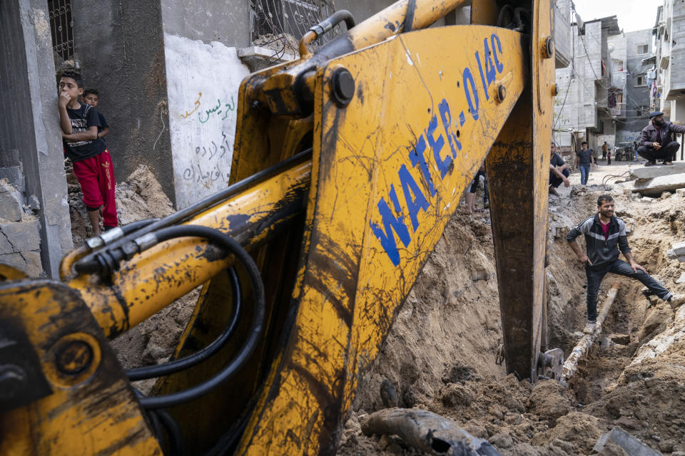 A hydraulic excavator operator works to clear a crater where the home of Ramez al-Masri was destroyed by an air-strike prior to a cease-fire reached after an 11-day war between Gaza's Hamas rulers and Israel, Sunday, May 23, 2021, in Beit Hanoun, the northern Gaza Strip. (AP Photo/John Minchillo)