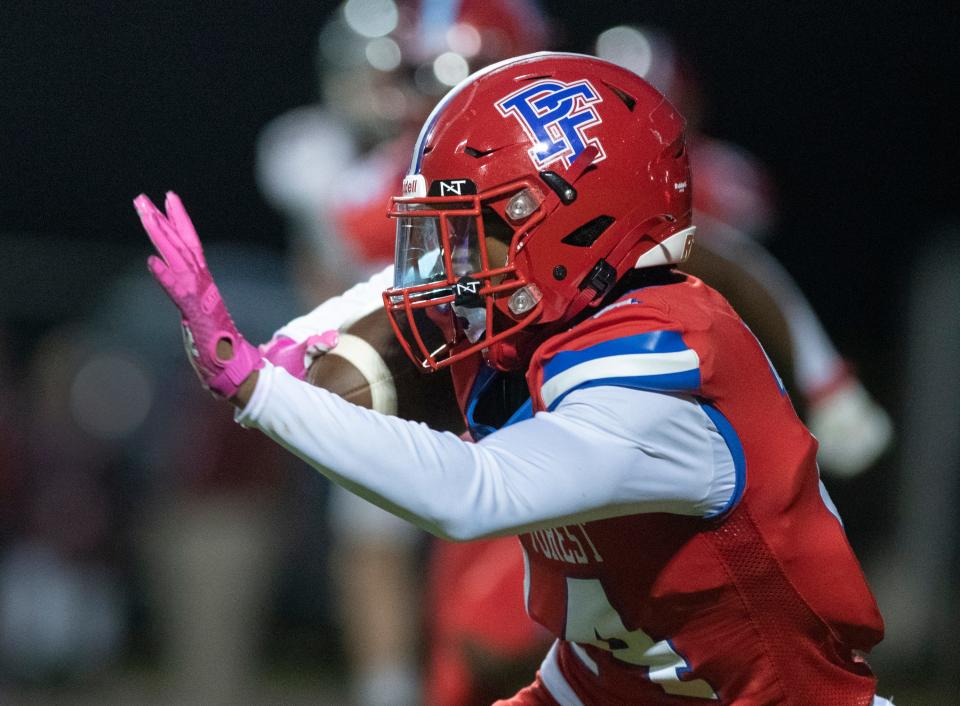 Donielle Hayes (14) carries the ball on a big pickup that gets called back on a penalty during the Tate vs Pine Forest football game at Pine Forest High School in Pensacola on Thursday, Aug. 25, 2022.