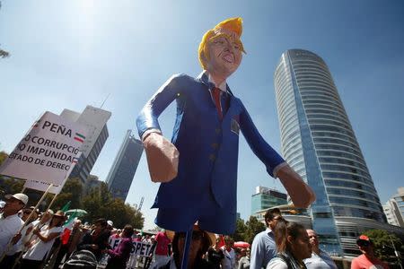 A woman carries an effigy of U.S. President Donald Trump during a march to protest against Trump's proposed border wall and to call for unity, in Mexico City, Mexico, February 12, 2017. REUTERS/Jose Luis Gonzalez