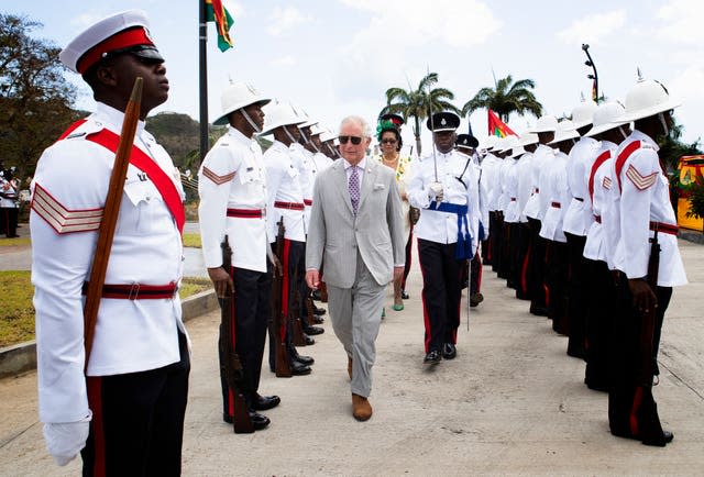 The then Prince of Wales inspects the troops during a welcome ceremony and reception at the Grenada Houses of Parliament building during a one-day visit to the Caribbean island of Grenada in 2019