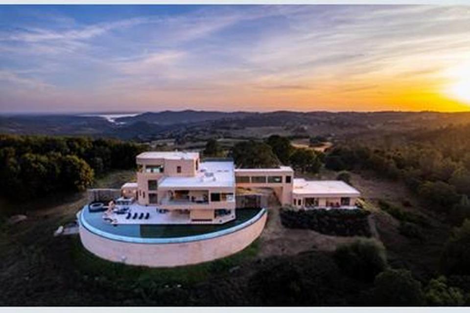 An infinity edge pool wraps around the back of the 40-acre home.