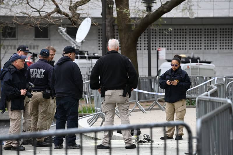 Members of New York City Fire Department (FDNY) inspect the scene in the aftermath of a man setting himself on fire, in the park across from the NYS Criminal Courthouse. According to US media reports, a man set himself on fire in a park opposite the courthouse in New York during the ongoing criminal trial of former president Donald Trump. Andrea Renault/ZUMA Press Wire/dpa