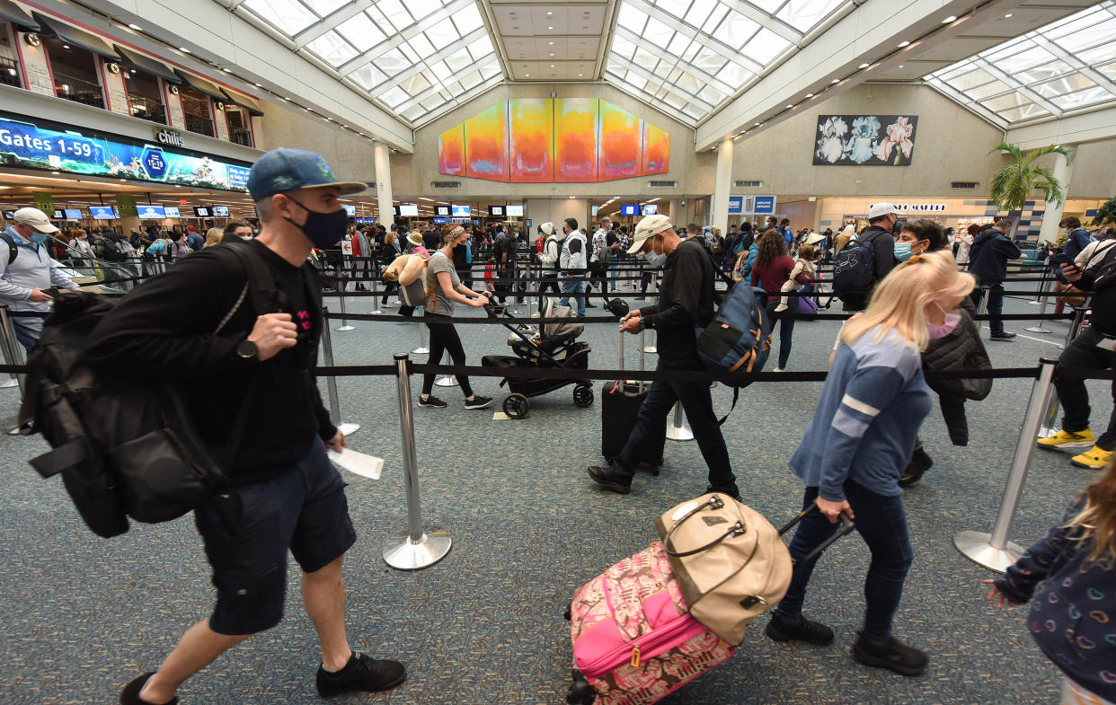 ORLANDO, FLORIDA, UNITED STATES - 2021/11/24: Travelers carry their bags and luggage while queuing at the Orlando International Airport on Thanksgiving Eve.
The Transportation Security Administration is expecting a record number of passengers for the Thanksgiving holiday period, surpassing the pre-pandemic records. (Photo by Paul Hennessy/SOPA Images/LightRocket via Getty Images)