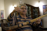 Pakistan's legendary field hockey player Samiullah shows a souvenir hockey stick during an interview with The Associated Press, in Karachi, Pakistan, Saturday, Nov. 12, 2022. There is only one sport that matters in Pakistan and that's cricket, a massive money-making machine. But minors sports like rugby are struggling to get off the ground due to lack of investment and interest, stunting their growth at home and chances of success overseas. Even previously popular sports like squash and field hockey, which Pakistan dominated for decades, can't find their form.(AP Photo/Fareed Khan)