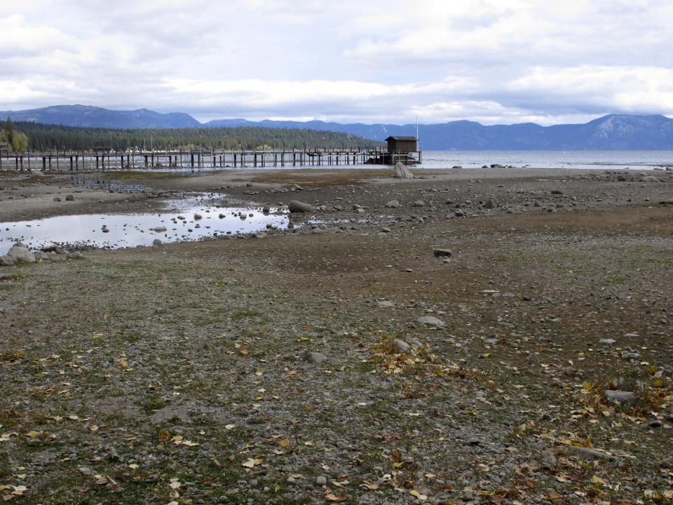 A pier and dock sits above Lake Tahoe's receding shoreline Wednesday, Oct. 20, 2021 at Tahoe City, Calif. Drought fueled by climate change has dropped Lake Tahoe below its natural rim and halted flows into the Truckee River, an historically cyclical event that's occurring sooner and more often than it used to raising fears about what might be in store for the famed alpine lake. (AP Photo/Scott Sonner).