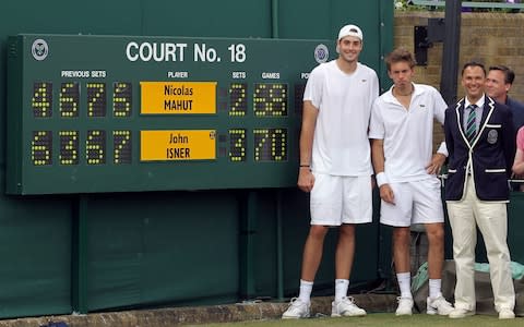 John Isner and Nicolas Mahut in front of the scoreboard after their match at Wimbledon  - Credit: Getty Images