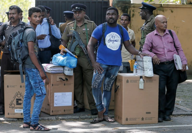 Sri Lankan police and election officials wait to load ballot boxes and papers into busses from a distribution center to polling stations, ahead of country's presidential election scheduled on November 16, in Colombo