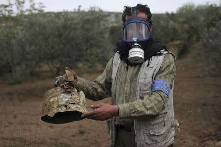 FILE PHOTO: A Civil Defence member carries a damaged canister in Ibleen village from what activists said was a chlorine gas attack, on Kansafra, Ibleen and Josef villages, Idlib countryside, Syria May 3, 2015. REUTERS/Abed Kontar/File Photo