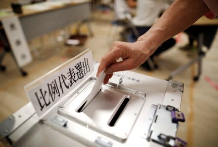 A voter casts a ballot at a voting station during Japan's upper house election in Tokyo