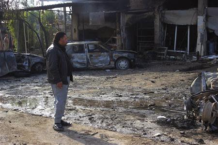 A man looks at the site of car bomb attack in Buhriz, 60 km (35 miles) northeast of Baghdad December 9, 2013. REUTERS/Mohammed Adnan