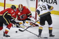 Vegas Golden Knights' Reilly Smith, right, shoots against Calgary Flames goalie David Rittich during first-period NHL hockey game action in Calgary, Alberta, Sunday, March 8, 2020. (Jeff McIntosh/The Canadian Press via AP)