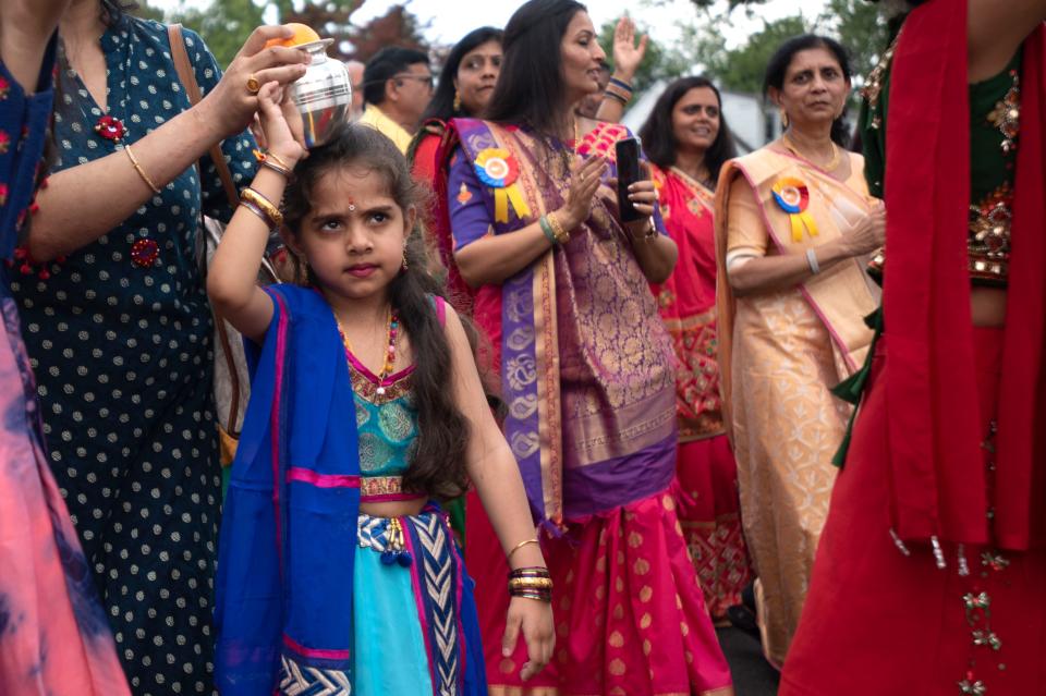 Girls in the community carry little pots of water and fruits on their head while walking aroud the building as a part of the Prana Pratishtha, grand opening, activities at Samarpan Hindu Temple & Community Center in Bensalem on Friday, June 24, 2022. The water is believed to be purified with this activity to be used in washing of gods later.