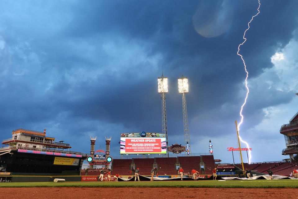 CINCINNATI, OH – SEPTEMBER 5: Grounds crew pull the tarp on the field as lightning from an approaching storm strikes in the distance during the third inning of a game between the <a class="link " href="https://sports.yahoo.com/mlb/teams/cincinnati/" data-i13n="sec:content-canvas;subsec:anchor_text;elm:context_link" data-ylk="slk:Cincinnati Reds;sec:content-canvas;subsec:anchor_text;elm:context_link;itc:0">Cincinnati Reds</a> and the <a class="link " href="https://sports.yahoo.com/mlb/teams/milwaukee/" data-i13n="sec:content-canvas;subsec:anchor_text;elm:context_link" data-ylk="slk:Milwaukee Brewers;sec:content-canvas;subsec:anchor_text;elm:context_link;itc:0">Milwaukee Brewers</a> at Great American Ball Park on September 5, 2015 in Cincinnati, Ohio. (Photo by Jamie Sabau/Getty Images)