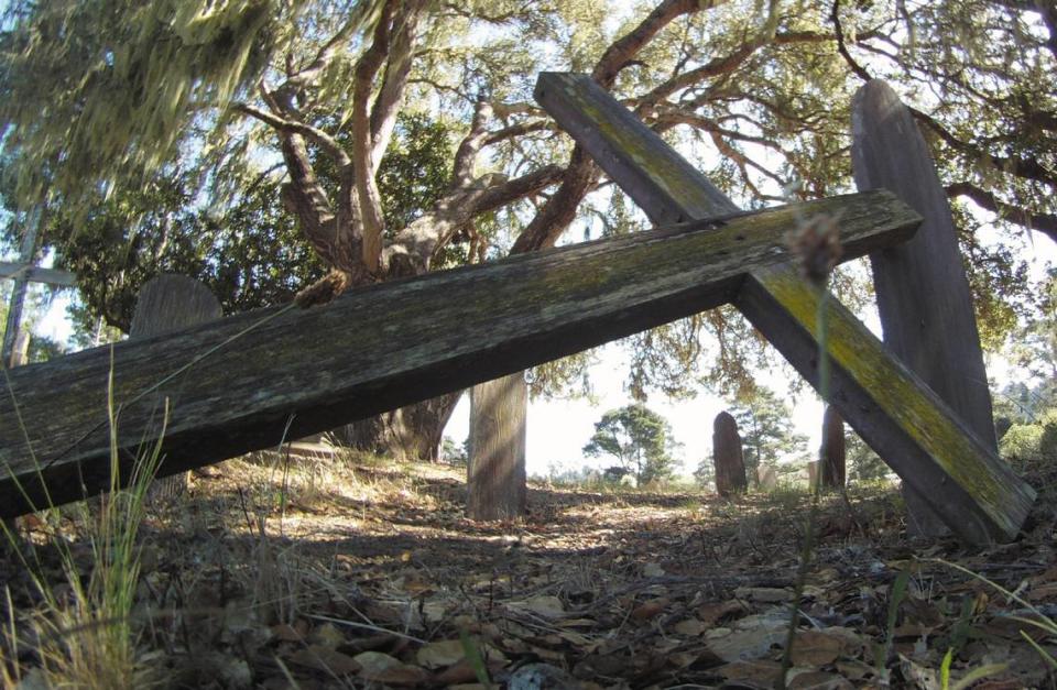 An old cross leans against a wooden tombstone at the Santa Rosa Cemetery in Cambria.