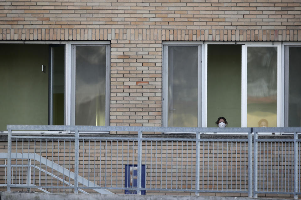 A nurse wearing a sanitary mask watches from a window of the hospital of Codogno, near Lodi in Northern Italy, Friday, Feb. 21,2020. Health officials reported the country's first cases of contagion of COVID-19 in people who had not been in China. The hospital in Codogno is one of the hospitals - along with specialized Sacco Hospital in Milan - which is hosting the infected persons and the people that were in contact with them and are being isolated. (AP Photo/Luca Bruno)