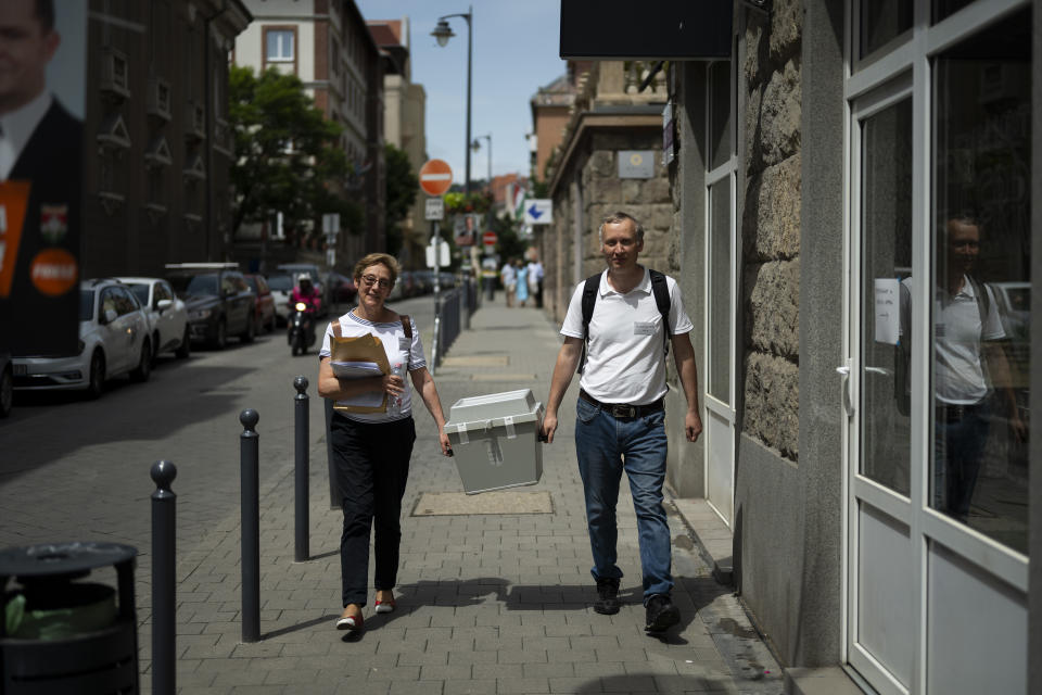 Ballot counters walk with a mobile ballot box during the European Parliamentary elections in Budapest, Hungary, Sunday, June 9, 2024. (AP Photo/Denes Erdos)