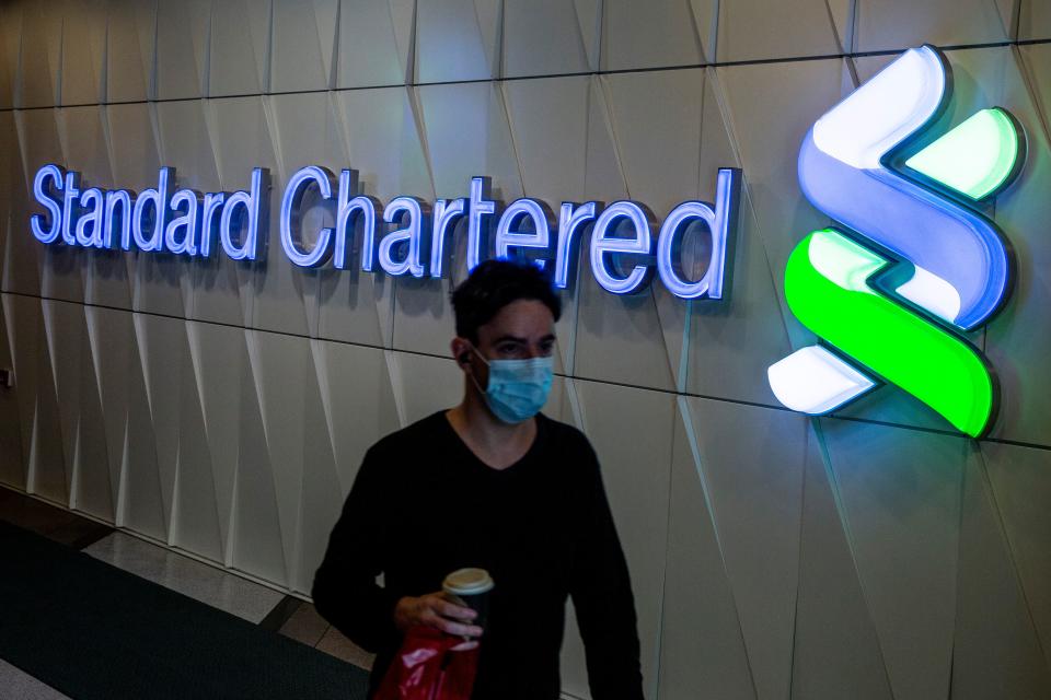 A man walks past a Standard Chartered sign in Hong Kong on February 27, 2020. - Standard Chartered said that its pre-tax profit rose to 4.2 billion USD in 2019, but warned that the income growth will be lower than target in 2020 over coronavirus woes. (Photo by ISAAC LAWRENCE / AFP) (Photo by ISAAC LAWRENCE/AFP via Getty Images)