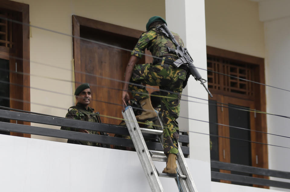 A Sri Lankan police commando enters a house suspected to be a hideout of militants following a shoot out in Colombo, Sri Lanka, Sunday, April 21, 2019. More than hundred were killed and hundreds more hospitalized with injuries from eight blasts that rocked churches and hotels in and just outside of Sri Lanka's capital on Easter Sunday, officials said, the worst violence to hit the South Asian country since its civil war ended a decade ago. (AP Photo/Eranga Jayawardena)