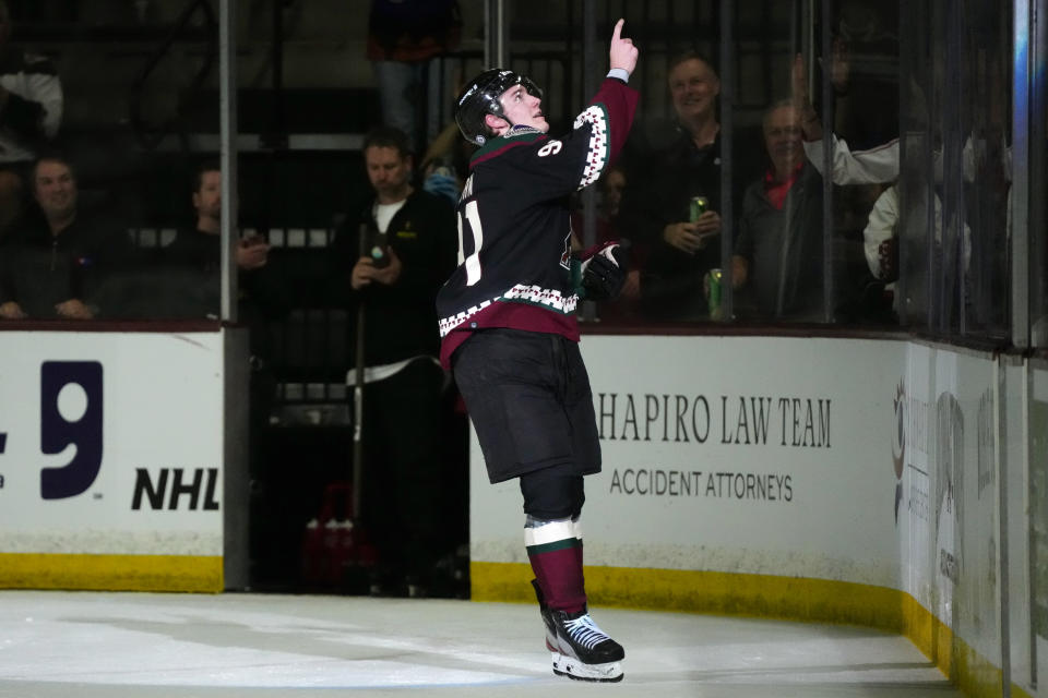 Arizona Coyotes' Josh Doan points to the crowd after getting the first star award, after the team's NHL hockey game against the Columbus Blue Jackets on Tuesday, March 26, 2024, in Tempe, Ariz. Doan scored two goals in his first NHL game, which the Coyotes won 6-2. (AP Photo/Ross D. Franklin)