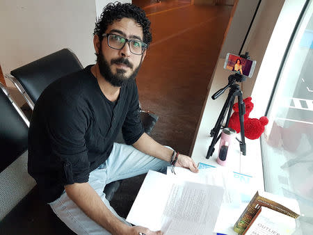 Syrian refugee Hassan Al Kontar sits in his "office" at the Kuala Lumpur International Airport, where he was stranded for seven months, in Kuala Lumpur, Malaysia, August 3, 2018. Courtesy of Hassan Al Kontar/Handout via REUTERS