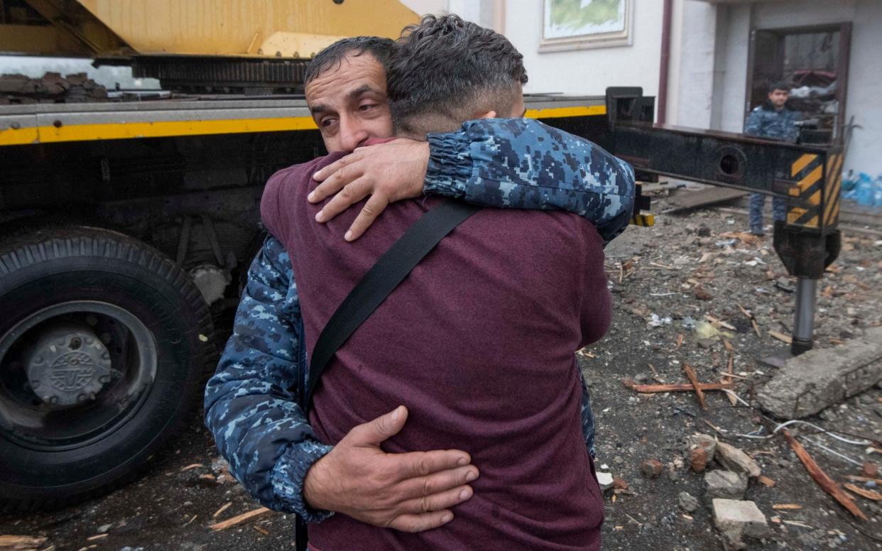 People grieve as bodies were removed from a central building in Shushi, hit by a missile on Sunday. Hostilities resumed between Armenian and Azerbaijan forces over the contested region of Nagorno-Karabakh on Oct 5th - JULIAN SIMMONDS