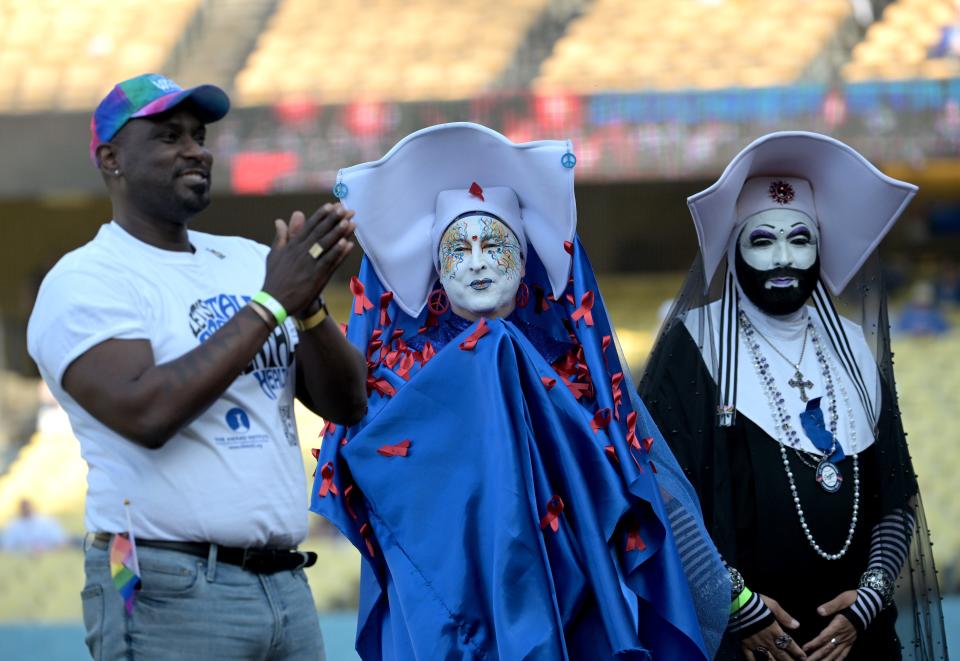Gerald Garth, LA Pride Board president applauds as Sister Unity and Sister Dominia of the Sisters of Perpetual Indulgence are given the Community Hero Award on Pride Night prior to the game between the Los Angeles Dodgers and the San Francisco Giants at Dodger Stadium.