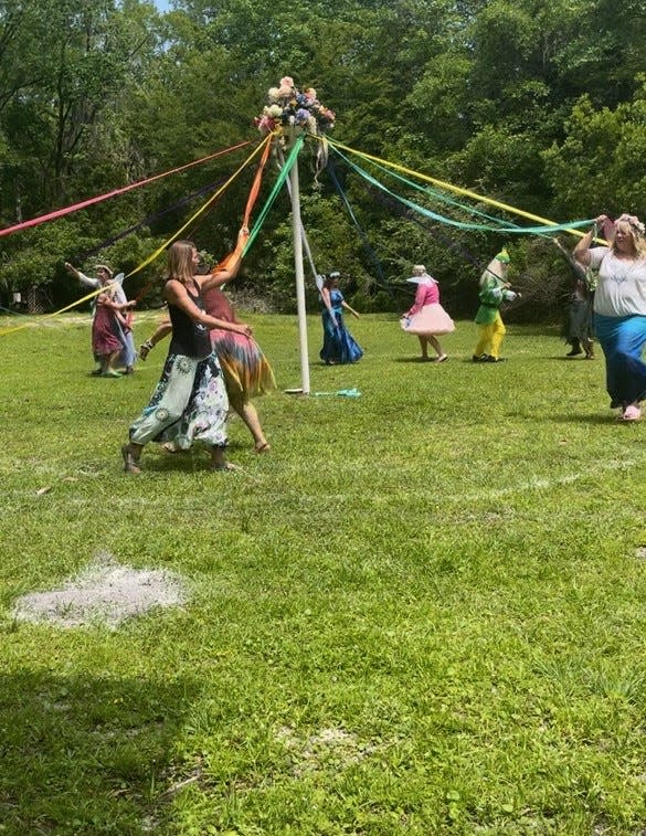 Community members of Mysterious Waters in Crawfordville dance around the May Pole to welcome spring.