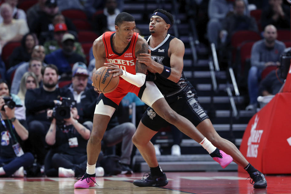 Houston Rockets forward Jabari Smith Jr., left, looks to drive around San Antonio Spurs forward Keldon Johnson, right, during the first half of an NBA basketball game Monday, Dec. 11, 2023, in Houston. (AP Photo/Michael Wyke)